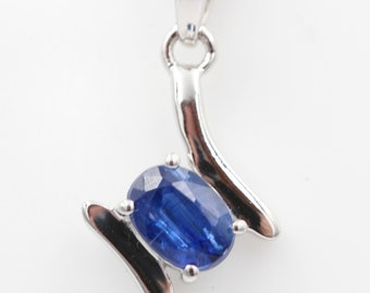 May include: A silver pendant necklace with a blue oval gemstone set in a silver swirl design.