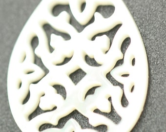 May include: A white, pearlescent guitar pick with a decorative, intricate, cut-out design.