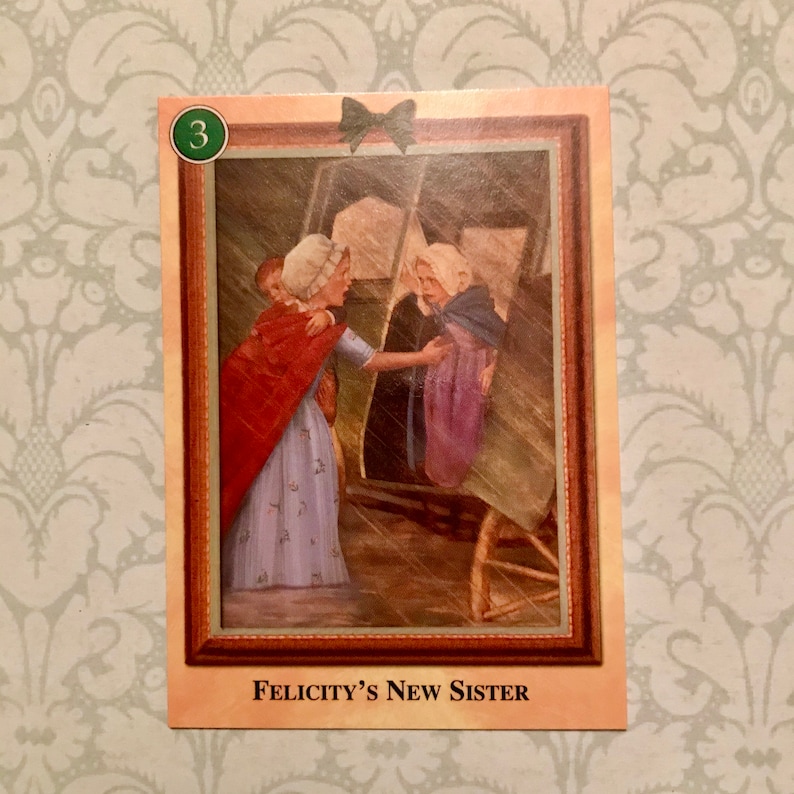 K&ouml;nnte beinhalten: Eine Illustration im Vintage-Stil einer Frau in einem roten Umhang und einem blauen Kleid, die ein junges M&auml;dchen in einem violetten Kleid und einem blauen Umhang begr&uuml;&szlig;t. Der Text "Felicity's New Sister" ist unter dem Bild gedruckt.