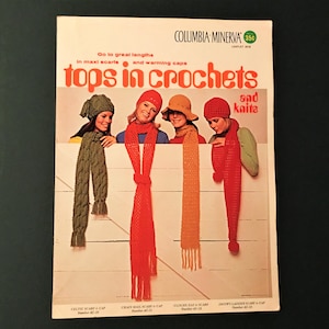 May include: Vintage magazine cover featuring women modeling crocheted scarves and caps in various colors. The cover text reads "Tops in Crochets and Knits" with additional text about maxi scarves and warming caps. The magazine is from Columbia Minerva.