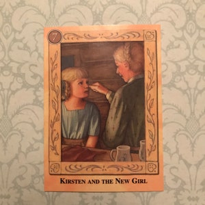K&ouml;nnte beinhalten: Eine Karte aus der Buchreihe "Kirsten", die eine Illustration von zwei M&auml;dchen in einer Holzh&uuml;tte zeigt. Die Karte ist mit "7" nummeriert und tr&auml;gt den Titel "Kirsten und das neue M&auml;dchen".