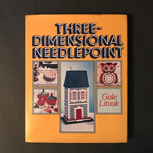 May include: Book cover with the title "Three-Dimensional Needlepoint" by Gale Litvak. The cover features three needlepoint projects: a house, an owl, and a strawberry basket.