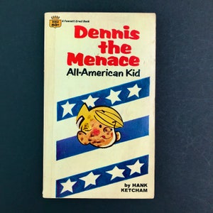 May include: A vintage paperback book cover featuring a cartoon illustration of Dennis the Menace, an all-American kid, with the title "Dennis the Menace All-American Kid" and the author "Hank Ketcham".