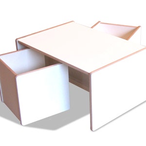 May include: White wooden table with two attached storage boxes. The table has a light wood trim around the edges.
