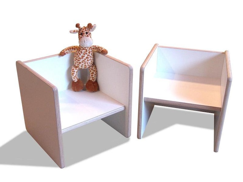 May include: Two white wooden chairs with a stuffed giraffe toy sitting on one of the chairs.