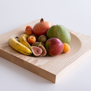 Puede incluir: Un cuenco de madera lleno de una variedad de frutas, incluyendo pl&aacute;tanos, higos, manzanas, mangos y granadas.