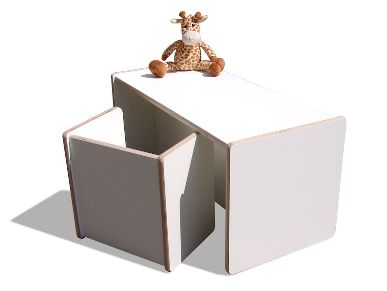 May include: White children's table and chair set with a stuffed giraffe toy on top of the table.