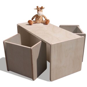May include: A light wood children's table and four chairs with storage compartments. A stuffed giraffe toy sits on the table.