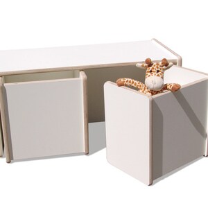 May include: White wooden storage bench with two drawers and a separate cube storage unit. A stuffed giraffe toy is peeking out of the top of the cube.