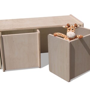 May include: A light wood toy storage bench with two doors and a separate cubby. The bench has a natural wood finish and is designed for children's playrooms.