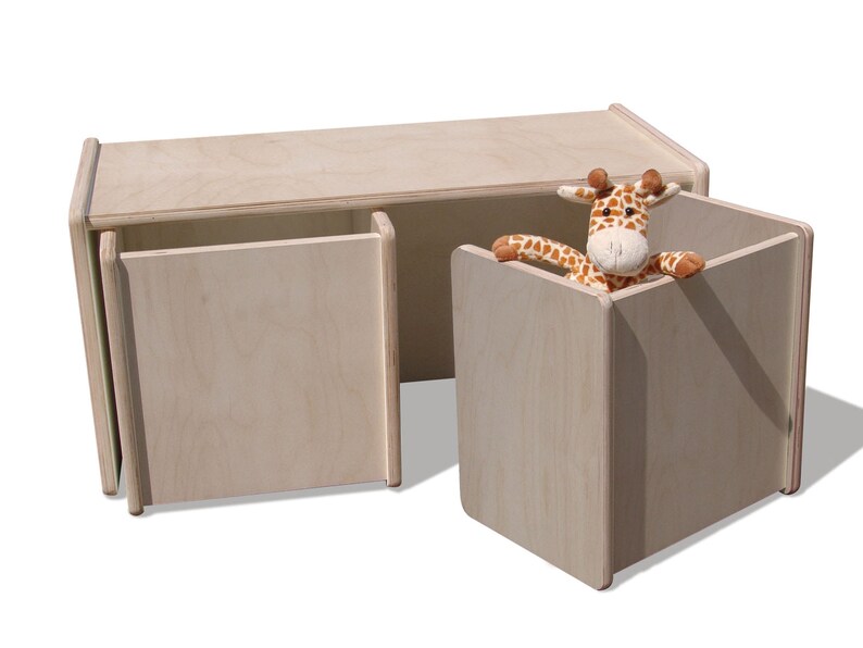 May include: A light wood toy storage bench with two doors and a separate cubby. The bench has a natural wood finish and is designed for children's playrooms.