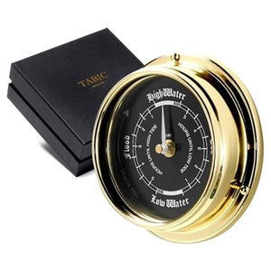 Può includere: Un orologio a marea dorato con un quadrante nero. L'orologio ha un ago che punta alle ore fino all'alta marea e alla bassa marea. Il quadrante dell'orologio indica "Alta marea" e "Bassa marea".