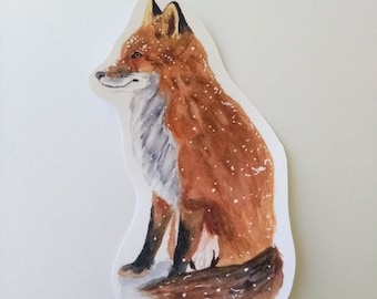 May include: Watercolor painting of a red fox sitting with its tail curled around its body. The fox is depicted in a snowy setting, with white specks of paint representing snow.