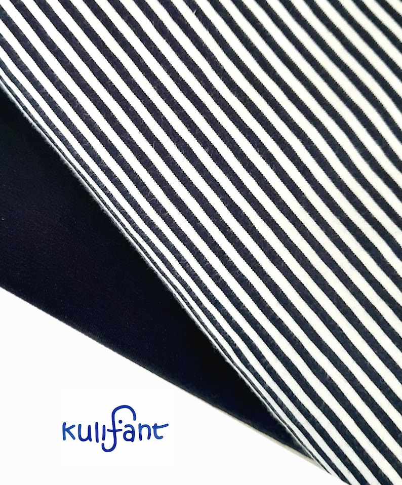 May include: A piece of fabric featuring a pattern of thin, dark navy blue and white vertical stripes, folded over to reveal a solid dark navy blue underside. The word kulifant is printed in blue text at the bottom left corner of the image.