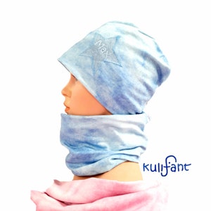 Może przedstawiać: Jasnoniebieski zestaw czapki i komina z efektem tie-dye. Czapka posiada gwiazdę z wyhaftowanym imieniem "Max". Zestaw wykonany jest z miękkiej tkaniny i jest odpowiedni dla dzieci.