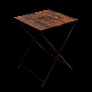 Peut inclure: Petite table d'appoint carr&eacute;e avec un plateau en bois brun fonc&eacute; et une base pliante en m&eacute;tal fonc&eacute;. Le plateau est fait de planches de bois et la base a un design en forme de X. La table mesure environ 61 cm de haut.