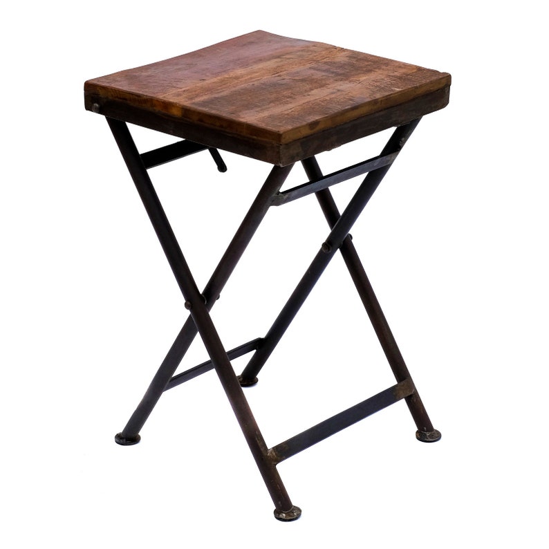 Peut inclure: Petite table d'appoint pliante avec un plateau rectangulaire en bois vieilli. La table a un cadre en m&eacute;tal fonc&eacute; avec un design en forme de X pour les pieds. La table mesure environ 46 cm de haut et 38 cm de large.