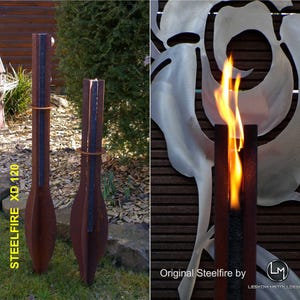 May include: Two tall, rusted metal sculptures with black accents. The sculptures are shaped like a teardrop and have a flame-like design. The text "STEELFIRE XD 120" is visible on the left sculpture. The sculptures are in a garden setting.