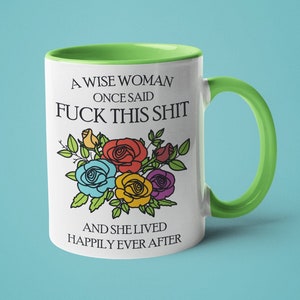 Puede incluir: Taza de cer&aacute;mica blanca con borde y asa verdes. La taza presenta una ilustraci&oacute;n en blanco y negro de rosas de colores y el texto "A wise woman once said Fuck this shit and she lived happily ever after."