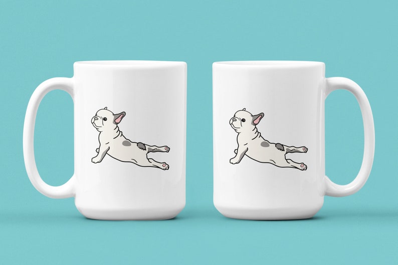 May include: Two white ceramic mugs with a black outline of a French bulldog doing a yoga pose on each mug.