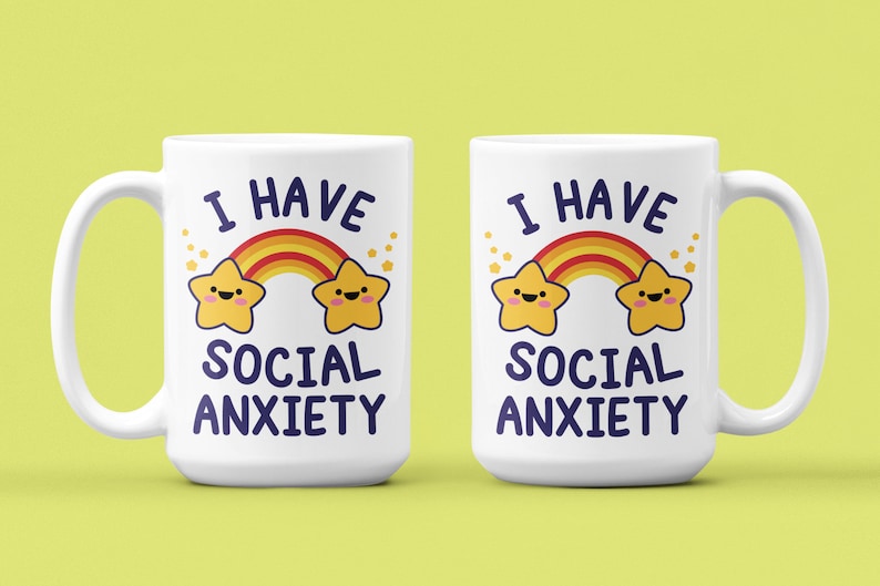 May include: Two white coffee mugs with a rainbow and two stars with faces. The text on the mugs reads "I have social anxiety".