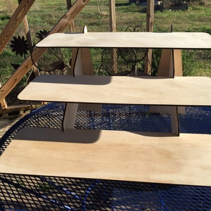 Puede incluir: Un expositor de madera de tres niveles con un acabado de madera natural. El expositor est&aacute; hecho de madera contrachapada y tiene un dise&ntilde;o simple y moderno.