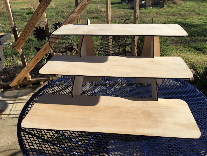 Puede incluir: Un expositor de madera de tres niveles con un acabado de madera natural. El expositor est&aacute; hecho de madera contrachapada y tiene un dise&ntilde;o simple y moderno.
