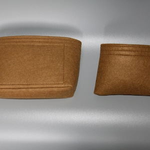 Könnte beinhalten: Zwei braune Filztaschen-Einsätze, einer größer als der andere. Beide haben ein schwarzes Etikett mit dem Text "felt22.de".