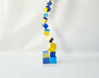 Wood sculpture. Hand painted wooden cubes of different sizes in blue and yellow tones. Tower design for modern decoration. Customize colors