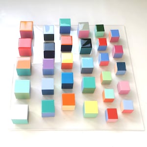 Wood wall art, modern 3d artwork. Sculpture wall art with resin finish on top face. Happy and colorful wood cubes. 24&quot; Acrylic glass base.