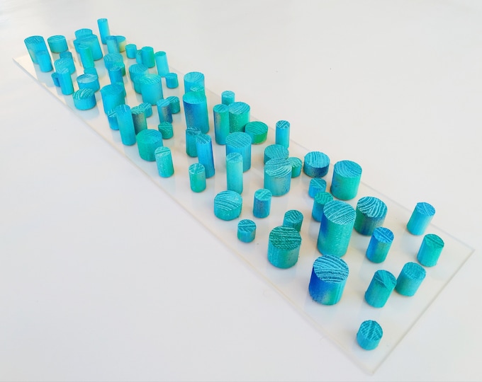 Unique© different piece of art in wood. Blue hand painted wooden dowels in recycled wood. Ocean, sea, beach, coastal theme. Transparent base
