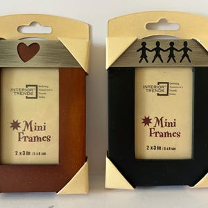 May include: Two mini picture frames, one brown and one black, each with a 2x3 inch (5x8 cm) opening. The brown frame has a heart cutout, and the black frame has a silhouette of people. Both are labeled "Mini Frames".