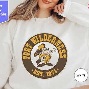 a woman wearing a white shirt with a logo on it