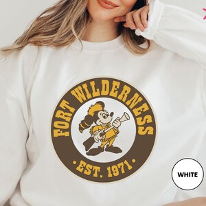 a woman wearing a white shirt with a logo on it