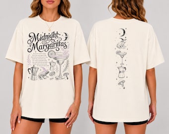 Könnte beinhalten: Ein cremefarbenes T-Shirt mit schwarzem Grafikdruck. Die Vorderseite zeigt den Text Midnight Margaritas mit Illustrationen eines Margaritaglases, einer Espressokanne, eines Frosches mit Hut und Pilzen. Die Rückseite zeigt ein vertikales Design.