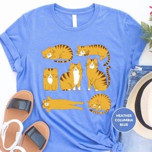 a blue t - shirt with three cats on it