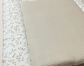 Könnte beinhalten: Eine weiße und beige Baby-Spielmatte mit einer Waffel-Oberfläche und einem Blatt-Muster. Die Matte ist perfekt für die Bauchzeit oder zum Spielen.