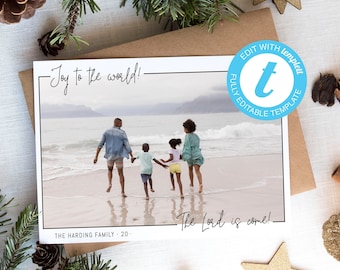 Può includere: Un biglietto di Natale con una famiglia di quattro persone che cammina su una spiaggia. Il biglietto ha il testo "Joy to the world!" e "The Lord is come!" con il nome della famiglia e l'anno.