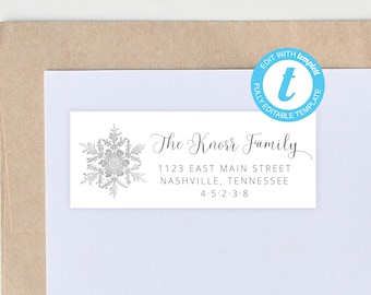 Op de afbeelding: Een wit rechthoekig etiket met een zilveren sneeuwvlokontwerp en de tekst "The Knorr Family". Het adres luidt "1123 EAST MAIN STREET, NASHVILLE, TENNESSEE, 4.5.2.3.8." Een blauwe cirkel met de tekst "EDIT WITH TEMPLETT" staat rechtsboven.