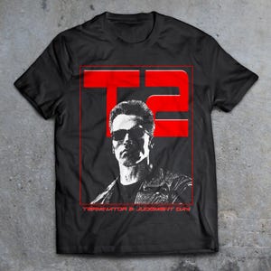 May include: Black t-shirt with a red "T2" graphic and a white image of Arnold Schwarzenegger as the Terminator from the movie Terminator 2: Judgment Day. The text "Terminator 2: Judgment Day" is printed below the image.