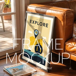 May include: A framed poster with the word "EXPLORE" in a black frame, leaning against a brown leather couch. The poster has a yellow background with a map graphic. A magazine lies on the wooden floor.