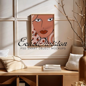 May include: A framed illustration of a woman's face with a colorful abstract background. The background features swirls of orange, red, and white. The woman's face is a light peach color with red lips and brown eyes. The frame is a light wood color.