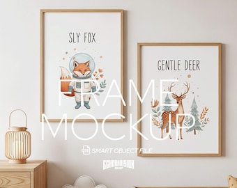 May include: Two framed art prints with wooden frames. One print features a fox in a spacesuit with the text "SLY FOX". The other print shows a deer with the text "GENTLE DEER". The prints are displayed in a nursery setting.
