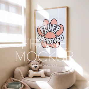 Puede incluir: Un estampado enmarcado con las palabras "FLUFF APPROVED" en un diseño de huella de pata. Una cama para perros con un osito de peluche y un juguete con forma de hueso está frente al estampado. Un cuenco y una manta para perros también están en la escena.