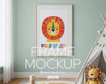 May include: A framed art print featuring a cartoon lion with a crown, surrounded by a red and orange mane. The text "ROAR OF JOY" is below the lion. The frame is displayed in a child's room with a teepee and a rainbow rug.