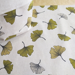 Op de afbeelding: Een beige stoffen opbergmand met een ginkgo-bladerenpatroon. De mand staat op een bijpassende stof met een ginkgo-bladerenpatroon.