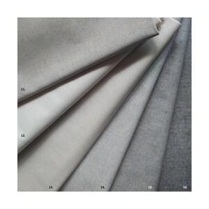 Könnte beinhalten: Stoffmuster in verschiedenen Grau- und Off-White-Tönen. Die Muster sind fächerförmig angeordnet und zeigen die unterschiedlichen Texturen und Farbtöne des Materials. Die Nummern 11 bis 16 sind auf dem Stoff zu sehen.