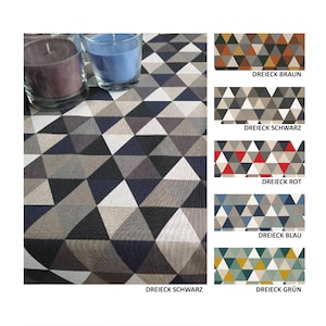 Könnte beinhalten: Eine Tischdecke mit einem geometrischen Muster aus schwarzen, grauen und weißen Dreiecken. Die Tischdecke ist mit zwei Kerzen in Glasbehältern abgebildet. Das Bild zeigt auch fünf verschiedene Farbvarianten des gleichen Musters: Braun, Schwarz, Rot, Blau und Grün.