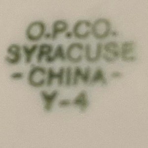 May include: Close-up of a green and white ceramic mark that reads "O.P.CO. SYRACUSE - CHINA - Y-4".