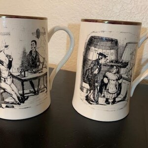 手描きのヘンリー・ヒースのデザインとトム・ムーアの引用句の金色の縁取りが施された、素晴らしいヴィンテージのグレイズ・ポタリー・イングランドのビールジョッキ 2 個 (別売り)